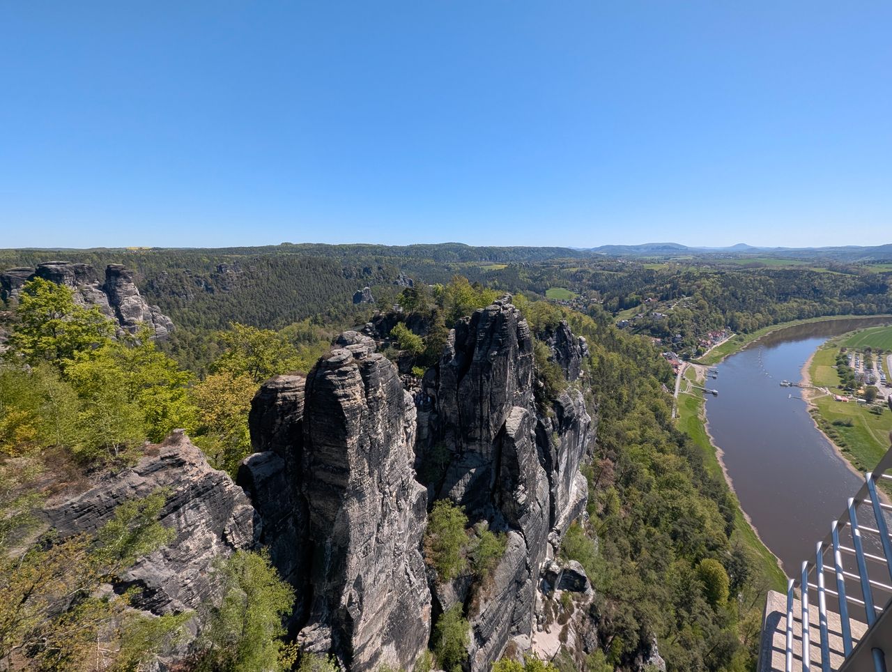 A breathtaking aerial view of the Elbe Sandstone Mountains and Elbe River under a clear blue sky.