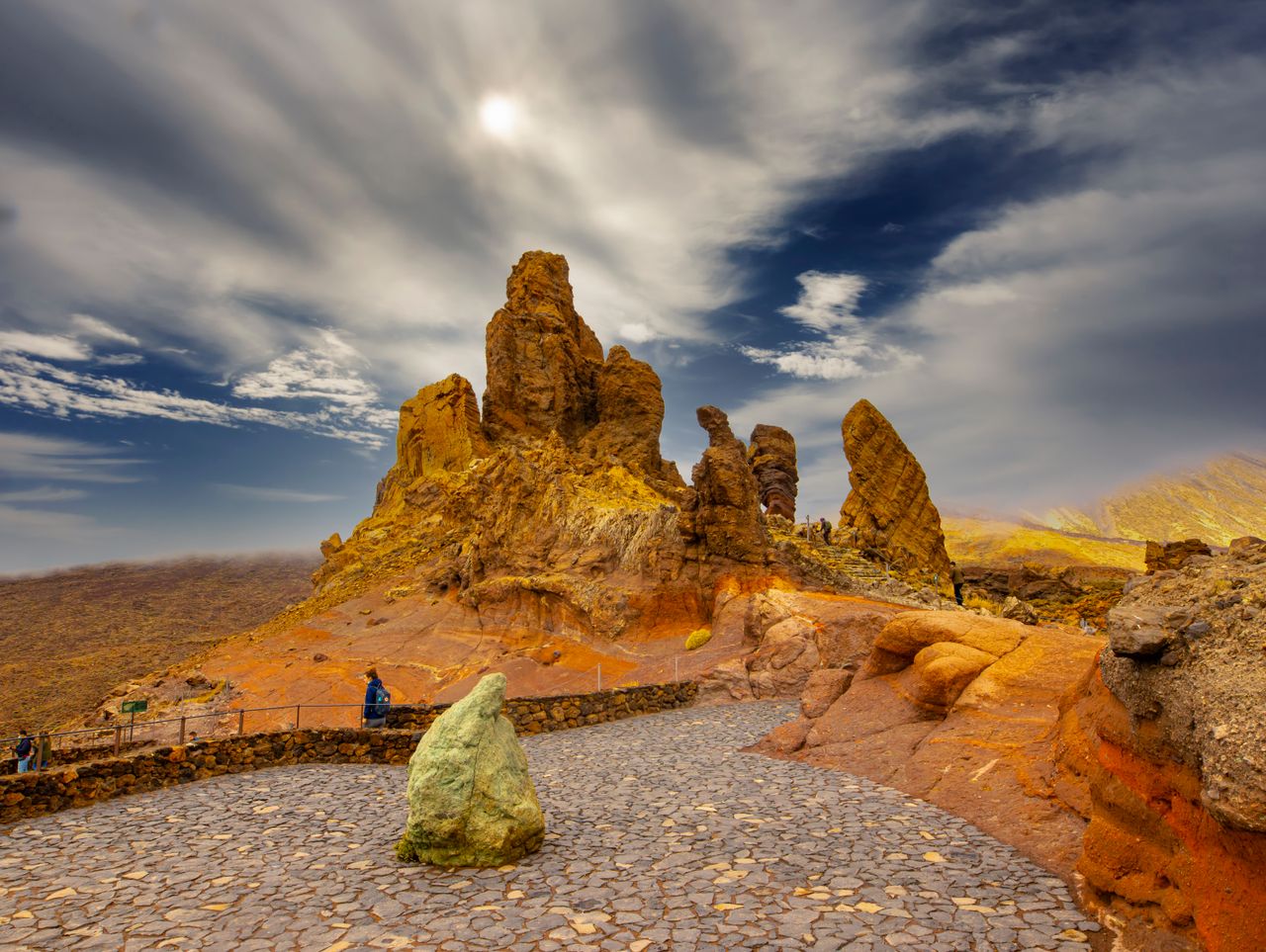 A breathtaking view of dramatic rock formations under a vibrant sky in a desert setting.